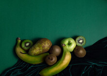 From Above Composition Of Fresh Natural Green Pear And Apple With Kiwi And Banana Arranged On Green Background