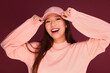 © Victor Torres/ADDICTIVE STOCK - Portrait of happy young asian woman in the studio wearing pink clothes over garnet background