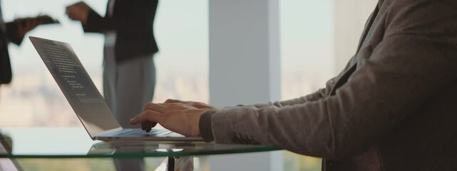 Programmer working in a software company office and typing a code.