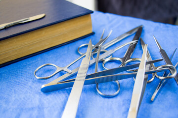 Sticker - Set of stainless dissecting kits with book on a blue sterile table