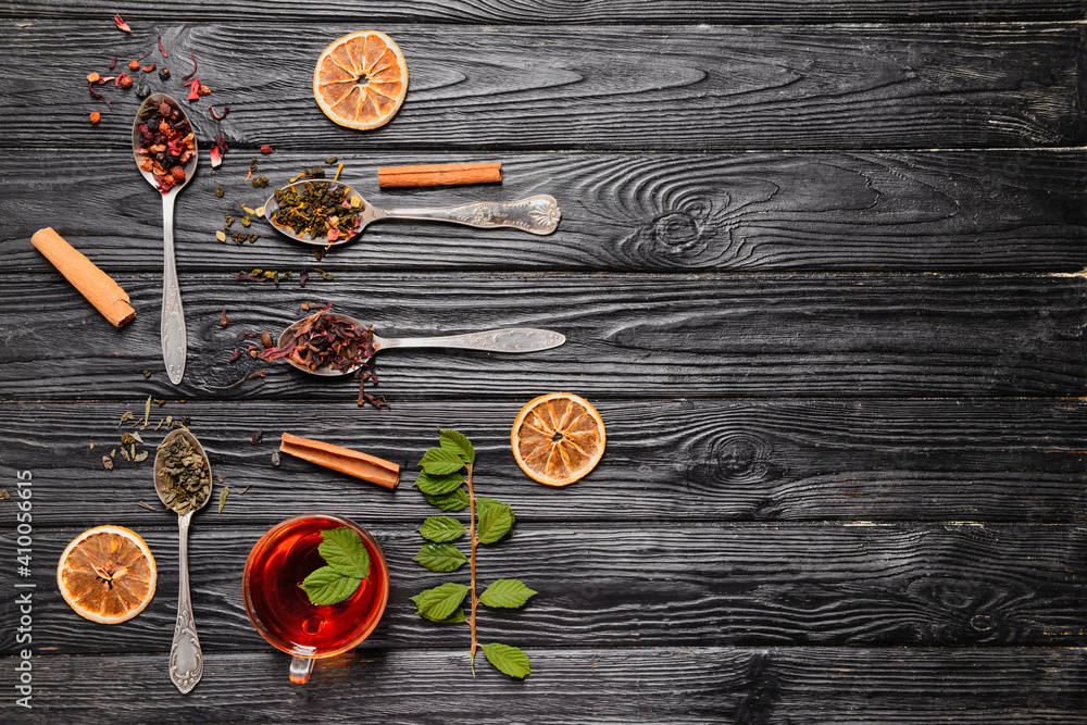Composition with cup and dry tea leaves on dark background