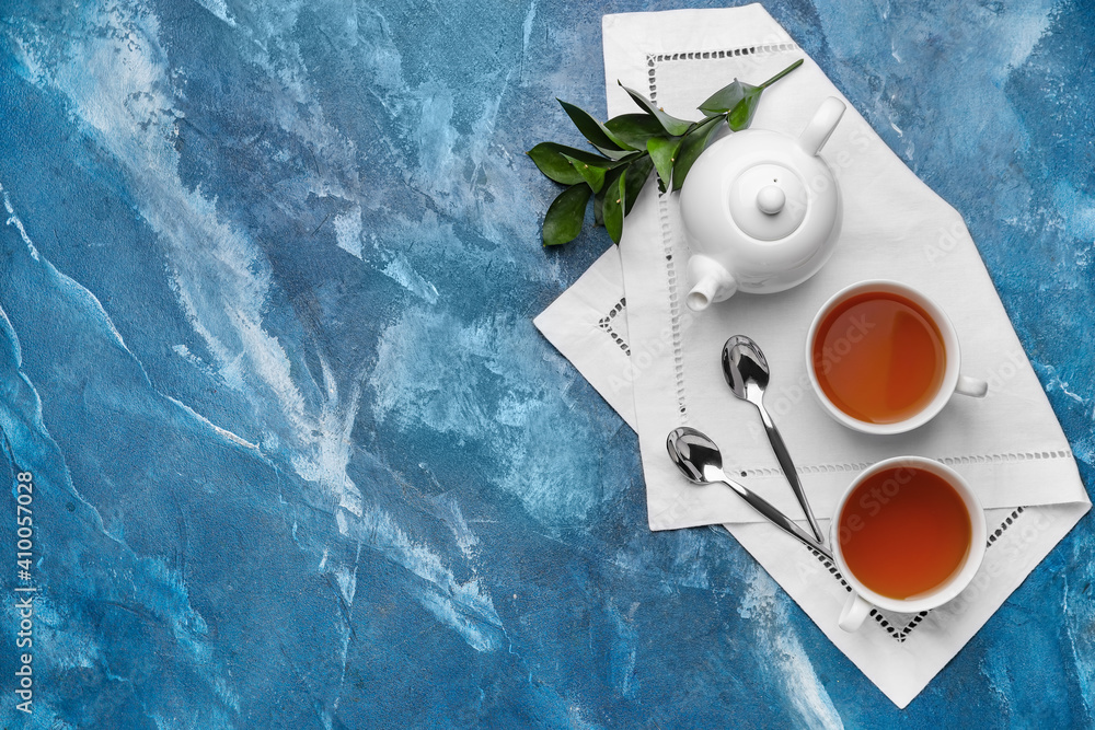 Composition with teapot and cups of tea on color background