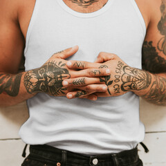 Wall Mural - Tattooed man clasping his hands on hit stomach while lying on the floor