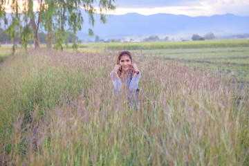 Poster - A woman is sitting in the rice field