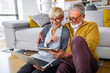 © NDABCREATIVITY - Senior couple websurfing on internet with laptop at home
