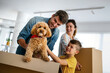 © NDABCREATIVITY - Happy family unpacking boxes in new home on moving day
