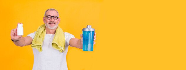 attractive senior man with bottle of vitamins or food supplements for sports. health and sport concept