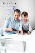 © epiximages - Family and childhood concept. Dad and son have fun together while they play a computer game.