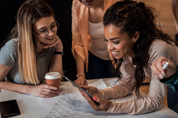 Group of women working together discussing architectural designs in the creative office.