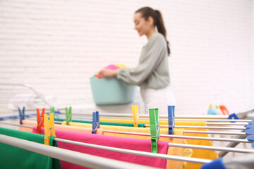 Wall Mural - Woman with laundry basket indoors, focus on drying rack. space for text