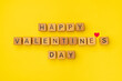 © Sergiy - Wooden cubes with the phrase Happy Valentine's Day on an empty colorful yellow background. Words of love are made of letters from wood for Valentine's Day and for your girlfriend, boyfriend, wife