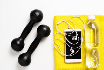 for sports, black dumbbells, phone, yellow towel, headphones, clean drinking water on a white background