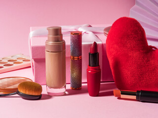 Wall Mural - Cosmetics beauty make up products background with red heart and gift box on pink. Valentines day