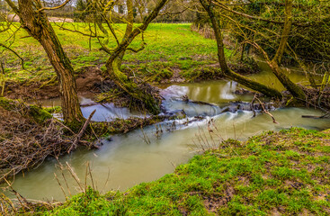 Wall Mural - A long exposure view of a small weir on the River Welland in winter near Lubenham, UK