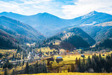 Fototapeta Góry - Beautiful forests covering the Carpathian mountains and a small village