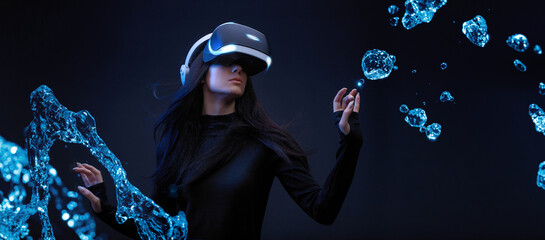Beautiful woman with flowing hair over dark magic background. Girl in glasses of virtual reality while touching air in blue neon lights. Augmented reality, game, future technology concept. VR.
