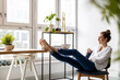 © pikselstock - Young woman relaxing in office with her bare feet on desk