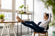© pikselstock - Young woman relaxing in office with her bare feet on desk
