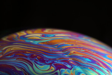 Macro picture of half soap bubble on black ground look like abstract psychedelic color planet in space	