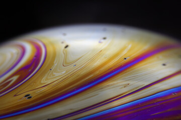 Wall Mural - macro picture of half soap bubble on black ground look like abstract psychedelic color planet in spa