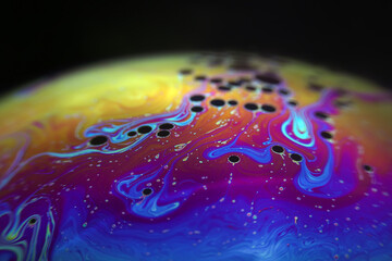 Wall Mural - macro picture of half soap bubble on black ground look like abstract psychedelic color planet in spa