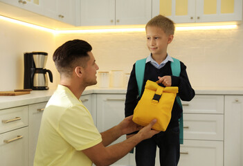 Sticker - Father helping his little child get ready for school in kitchen