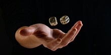 Female Hand Throwing White Dice In The Air On Black Background