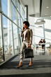 © BGStock72 - African American business woman using mobile phone and walking in the office