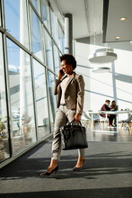 African American Business Woman Using Mobile Phone And Walking In The Office