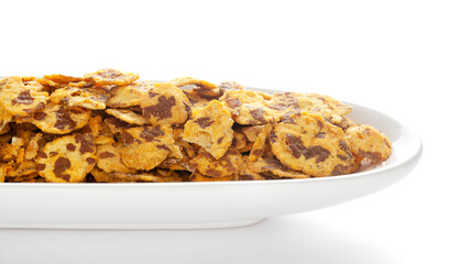 Wall Mural - Spicy Chana Jor Garam in a white ceramic oval bowl, made with air-fried Bengal Chickpea. Pile of Indian spicy snacks (Namkeen), under backlight, side view, against the white background.