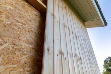 sheathing of a frame house with wooden clapboard. Imitation of a pine bar