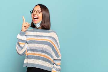 Canvas Print - young hispanic woman feeling like a happy and excited genius after realizing an idea, cheerfully raising finger, eureka!