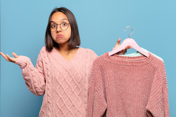 Canvas Print - young hispanic woman feeling puzzled and confused, doubting, weighting or choosing different options with funny expression