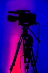 Vertical shot of a videography camera with a colorful background