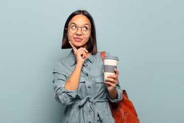 Wall Mural - young hispanic woman smiling happily and daydreaming or doubting, looking to the side