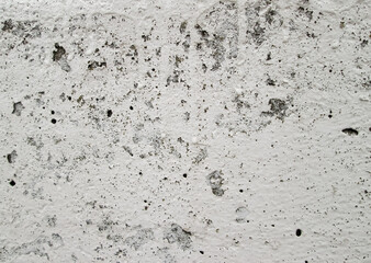 Cracks and hollows on a light concrete wall. Texture of old paint on a stone pavement.