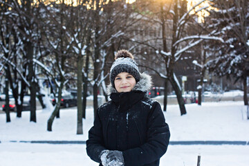 boy walks and has fun in the snow in the city park. winter walk, winter fun