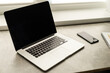 © Angelov - open laptop and smartphone on the table, workplace by the window