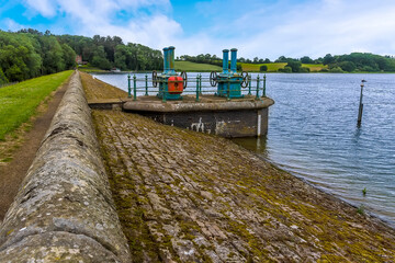 Wall Mural - A view along the eastern shore past the sluice gates on Raventhorpe Water, Northamptonshire, UK