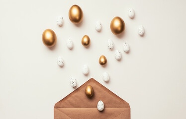 Wall Mural - Easter golden Eggs in envelope on white background. Happy Holiday message, correspondence concept. Flat lay, minimal style greeting card