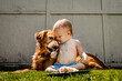 © Angela Waterton/Westend61 - Shirtless baby boy with Golden Retriever eating birthday cake on grassy land in yard