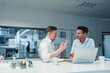 © Daniel Ingold/Westend61 - Male professionals with laptop having meeting at desk in industry office
