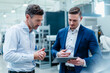 © Daniel Ingold/Westend61 - Business people working together on digital tablet in industry