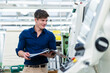 © Daniel Ingold/Westend61 - Smiling male engineer holding file document while examining manufacturing equipment in factory
