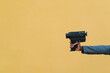 © Ezequiel Gim√©nez/Westend61 - Man holding 1980s camera against yellow wall