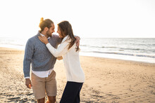 Happy Young Couple Embracing At Beach During Sunny Day