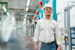 © Daniel Ingold/Westend61 - Confident mature manager wearing eyewear and hardhat contemplating in factory