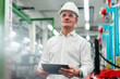 © Daniel Ingold/Westend61 - Mature businessman in hardhat holding digital tablet while looking away in factory