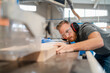© Daniel Ingold/Westend61 - Portrait of carpenter cutting plank of wood