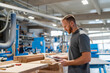 © Daniel Ingold/Westend61 - Portrait of carpenter standing in production hall with clipboard in hands